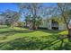 The condo exterior features lush green grass, mature trees, and a sunny blue sky above at 128 Nancy Dr # 128, Oldsmar, FL 34677
