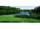 Scenic golf course view featuring lush green fairway, water hazard, and luxury homes in the background at 128 Nancy Dr # 128, Oldsmar, FL 34677