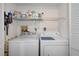Well-organized laundry room with washer, dryer, shelving and cleaning supplies at 128 Nancy Dr # 128, Oldsmar, FL 34677
