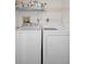 Bright laundry area with washer, dryer, and overhead shelving at 128 Nancy Dr # 128, Oldsmar, FL 34677