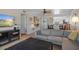 Cozy living room with a sectional sofa, entertainment center, and view into the kitchen at 128 Nancy Dr # 128, Oldsmar, FL 34677