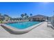 Community pool area featuring a building, lounge chairs, and clear blue sky on a sunny day at 128 Nancy Dr # 128, Oldsmar, FL 34677