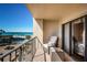 Relaxing balcony view of a sandy beach, swaying palm trees, and a community pool, perfect for unwinding at 1480 Gulf Blvd # 410, Clearwater Beach, FL 33767