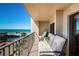 Charming balcony featuring outdoor seating with views of the turquoise ocean, palm trees, and community pool at 1480 Gulf Blvd # 410, Clearwater Beach, FL 33767