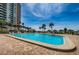 Large community pool with brick deck surrounded by tropical landscaping and ocean views at 1480 Gulf Blvd # 410, Clearwater Beach, FL 33767