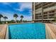 Large community pool with brick deck surrounded by tropical landscaping and ocean views at 1480 Gulf Blvd # 410, Clearwater Beach, FL 33767
