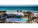 Inviting community pool on the beach with lounge chairs, a tiki hut, and swaying palm trees at 1480 Gulf Blvd # 410, Clearwater Beach, FL 33767