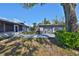 View of the backyard showcasing a spacious garage with a double door and a screened enclosure attached to the house at 1520 S Richard Ave, Tampa, FL 33629