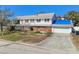 Two-story home featuring a balcony, brick accents, and a well-kept front yard with mature trees at 19 Sandpiper Rd, Tampa, FL 33609