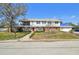 Charming two-story home featuring a red brick facade, white siding, a balcony, and a well-manicured front yard at 19 Sandpiper Rd, Tampa, FL 33609