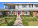 Charming two-story home with a brick facade, a bright red front door, and manicured landscaping at 19 Sandpiper Rd, Tampa, FL 33609