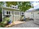 Charming shed with painted doors and trim, surrounded by brick pavers and colorful potted plants at 19 Sandpiper Rd, Tampa, FL 33609