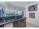 Basement wet bar with black countertop and view of living room at 201 Punta Vista Dr, St Pete Beach, FL 33706