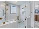 This white bathroom features a glass shower, white tile, and gold fixtures at 201 Punta Vista Dr, St Pete Beach, FL 33706
