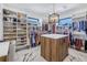 Custom walk-in closet featuring ample storage, display shelving, and a center island with counter space at 201 Punta Vista Dr, St Pete Beach, FL 33706
