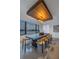 Dining room with sleek wood table, modern chandelier and beautiful water views at 201 Punta Vista Dr, St Pete Beach, FL 33706