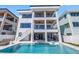 Contemporary three-story home with a pool, outdoor kitchen, and multi-level balconies overlooking the water at 201 Punta Vista Dr, St Pete Beach, FL 33706