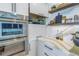Modern kitchen features stainless steel appliances, custom white cabinetry, and decorative floating shelves at 201 Punta Vista Dr, St Pete Beach, FL 33706