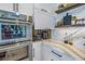 Kitchen featuring stainless steel appliances, white cabinets, and stone countertops at 201 Punta Vista Dr, St Pete Beach, FL 33706