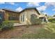 The backyard with a covered patio, surrounded by green plants at 2224 Vista Royal Way, Spring Hill, FL 34606