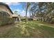 The backyard with a green lawn and mature trees with shade at 2224 Vista Royal Way, Spring Hill, FL 34606