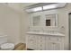 Bathroom with dual sink vanity, a swan accessory, white cabinets, and laminate floor at 2224 Vista Royal Way, Spring Hill, FL 34606