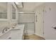Bathroom featuring dual sinks, a shower with glass doors, and a swan accessory on the counter at 2224 Vista Royal Way, Spring Hill, FL 34606