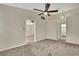 Neutral bedroom with carpeted floors, ceiling fan, and a partial view of the bathroom at 2224 Vista Royal Way, Spring Hill, FL 34606