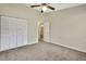 Neutral bedroom with carpeted floors, ceiling fan, and a partial view of the bathroom at 2224 Vista Royal Way, Spring Hill, FL 34606