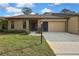 Charming single-story home showcasing a manicured lawn, quaint landscaping, and a welcoming facade at 2224 Vista Royal Way, Spring Hill, FL 34606