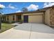 Exterior of home featuring a driveway, a two-car garage, and a stone accent wall at 2224 Vista Royal Way, Spring Hill, FL 34606