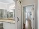Bathroom with sliding barn door features granite countertop vanity, a mirror, and tiled walk-in shower at 2713 Via Murano # 216, Clearwater, FL 33764