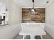 Dining room featuring a wood accent wall and modern lighting fixture above a white dining table at 2713 Via Murano # 216, Clearwater, FL 33764