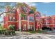 Charming red condo building with well-maintained landscaping and convenient attached garages at 2713 Via Murano # 216, Clearwater, FL 33764