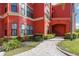 Close up of the lush greenery and walkway leading up to this red condominium at 2713 Via Murano # 216, Clearwater, FL 33764