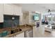 Kitchen opens to living room with fireplace and television and into the office, with granite counters at 2713 Via Murano # 216, Clearwater, FL 33764