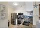 Kitchen with stainless steel appliances, granite countertops, white cabinets, and blue tile backsplash at 2713 Via Murano # 216, Clearwater, FL 33764