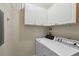 Functional laundry room with a washer, dryer, and white cabinetry for storage solutions at 2713 Via Murano # 216, Clearwater, FL 33764