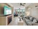 Bright living room featuring fireplace, ceiling fan, and large windows, inviting natural light at 2713 Via Murano # 216, Clearwater, FL 33764