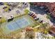 Aerial view of the well-maintained community tennis court, surrounded by mature trees and community parking at 2713 Via Murano # 216, Clearwater, FL 33764
