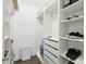 Bright walk-in closet with white built-in shelving, drawers, and ample storage space at 2713 Via Murano # 216, Clearwater, FL 33764