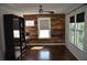 Sun-filled bedroom with rustic wood accent wall, ceiling fan, and dark wood floors at 2721 12Th N St, St Petersburg, FL 33704