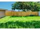 Large backyard with a wood fence for privacy and green grass at 3048 Holiday Lake Dr, Holiday, FL 34691