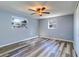 This bedroom is complete with light-blue walls, vinyl flooring, and two windows at 3048 Holiday Lake Dr, Holiday, FL 34691