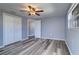 Bright bedroom showcasing a ceiling fan, closet, vinyl floors, and two windows at 3048 Holiday Lake Dr, Holiday, FL 34691