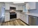 Modern kitchen featuring stainless steel appliances, and white cabinets at 3048 Holiday Lake Dr, Holiday, FL 34691