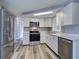 Modern kitchen featuring white cabinets, countertops, stainless steel appliances, and modern gray flooring at 3048 Holiday Lake Dr, Holiday, FL 34691