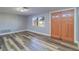 Bright and airy living room featuring modern gray flooring, a window, and a wooden front door at 3048 Holiday Lake Dr, Holiday, FL 34691