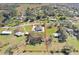 Wide aerial view of the property's location within a residential area with large green spaces on a partly cloudy day at 31049 Eloian Dr, Wesley Chapel, FL 33545