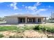 Back exterior view of a concrete block home under construction, featuring a covered patio and window installations at 31049 Eloian Dr, Wesley Chapel, FL 33545